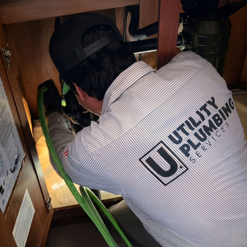 Utility Plumbing Services technician clearing drain clog